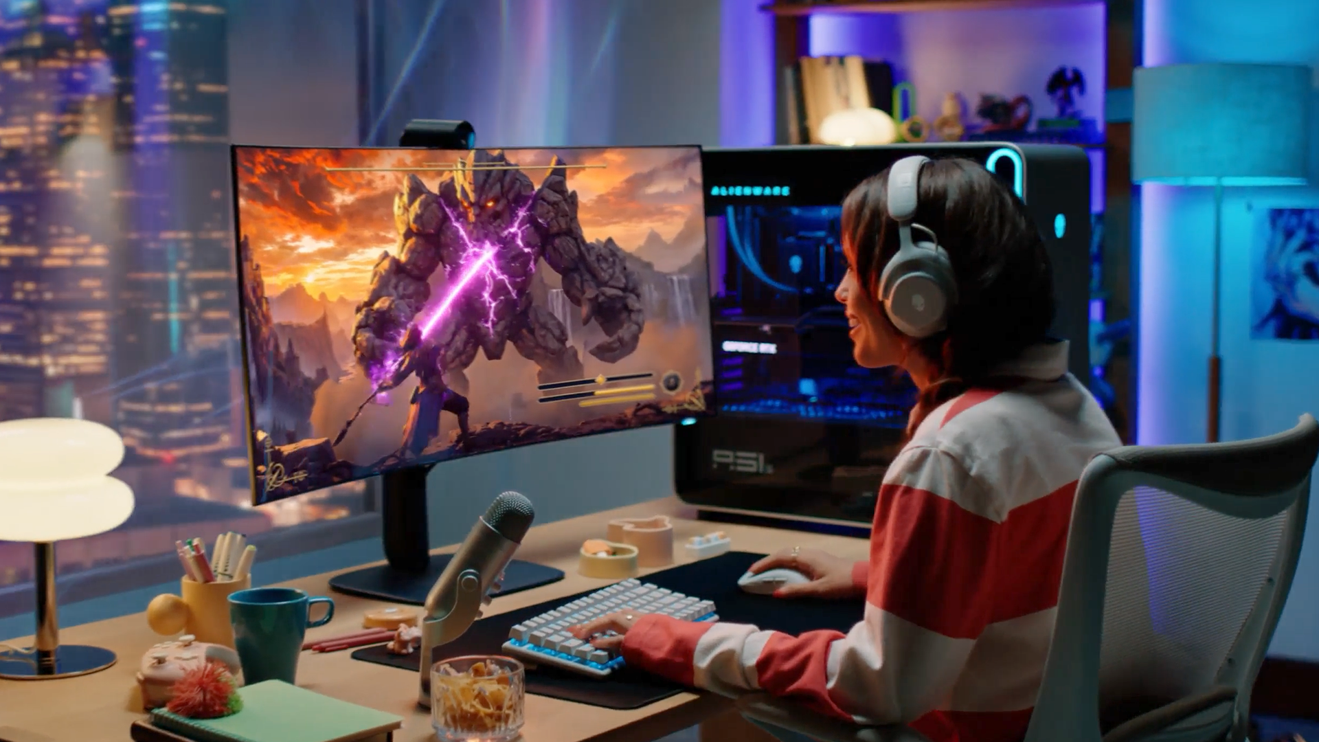 Side view of a gamer using the curved Alienware 39 5K OLED monitor with RGB stripe tandem OLED technology in an illuminated gaming desk setup.