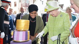 Queen Elizabeth II cuts into a cake made by Nadiya Hussein
