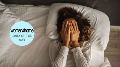 A woman in bed with her hands to her face