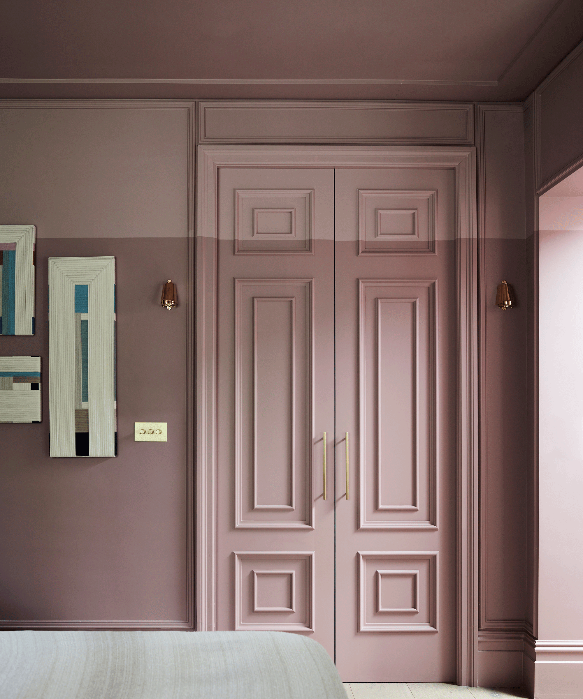A panelled bedroom door painted two different shades of pink