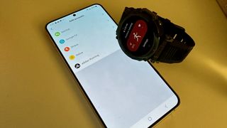 The Amazfit T-Rex Ultra next to an Android phone showing the Zepp app, in which you can sync to Adidas Running account.