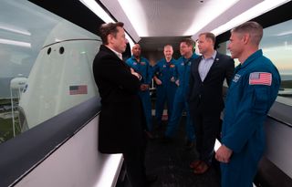 SpaceX founder Elon Musk talks with four NASA astronauts who would soon launch on the company's Crew Dragon spacecraft, as well as then-NASA Administrator Jim Bridenstine, in 2019.