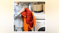 woman next to a washing machine holding a puffer coat demonstrating how to wash a puffer jacket