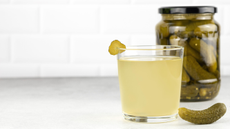 Pickles in a jar and a glass of pickle juice