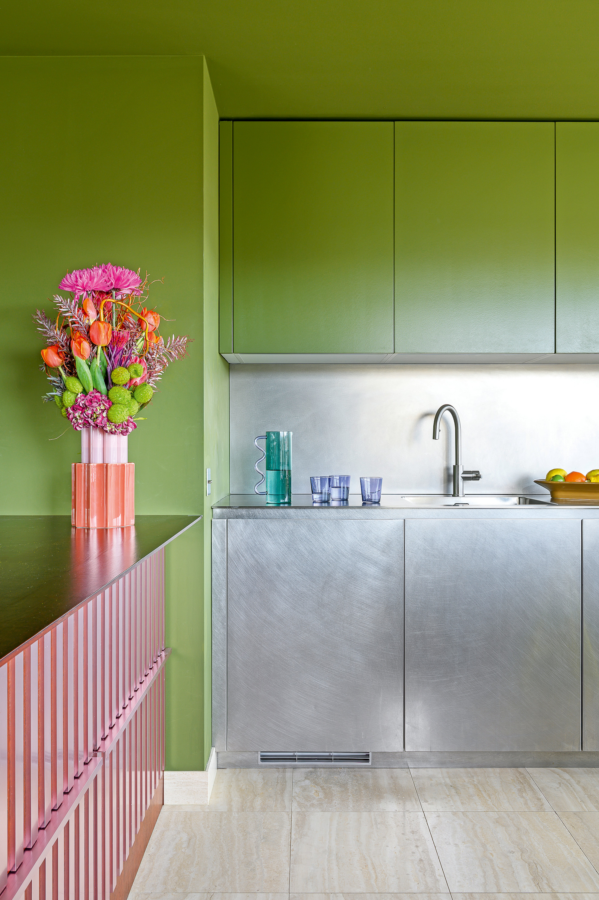 Stainless steel kitchen with matcha green wall units and pink striped bar area