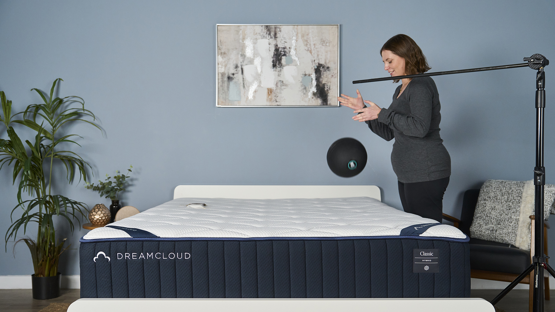 A Tom's Guide tester holds a 5kg slam ball over the DreamCloud Classic and then drops it, while an accelerometer on the other side of the mattress measures how much motion is absorbed