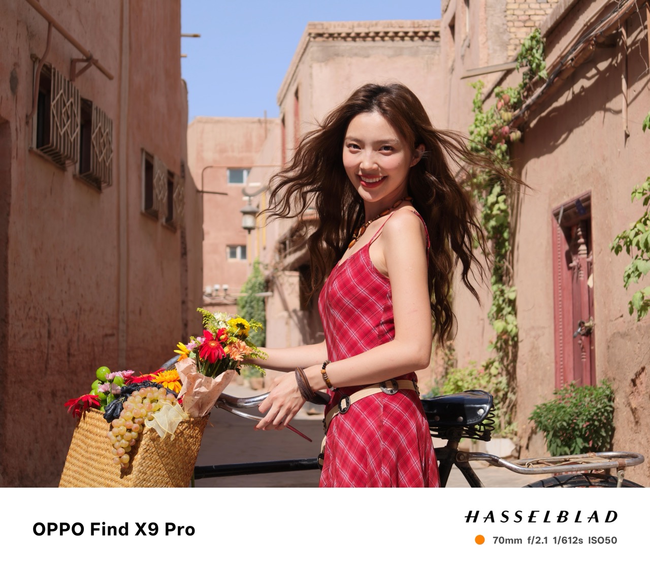 Woman in a red dress standing next to a bike with flowers in the basket taken on an Oppo Find X9 Pro