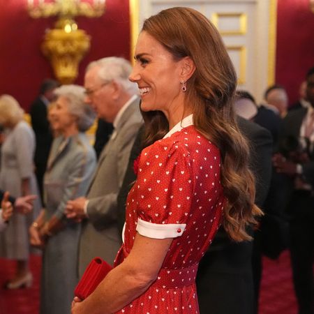 Princess Kate wearing a red dress and laughing 