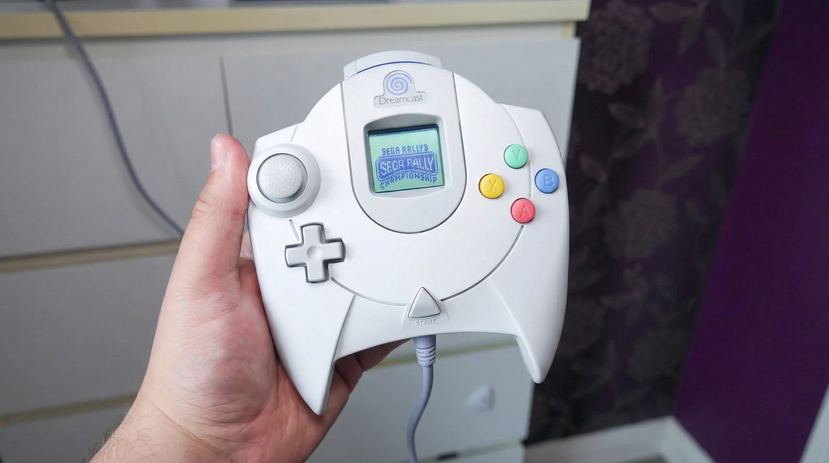 The Sega Dreamcast controller with VMU inserted playing Sega Rally.