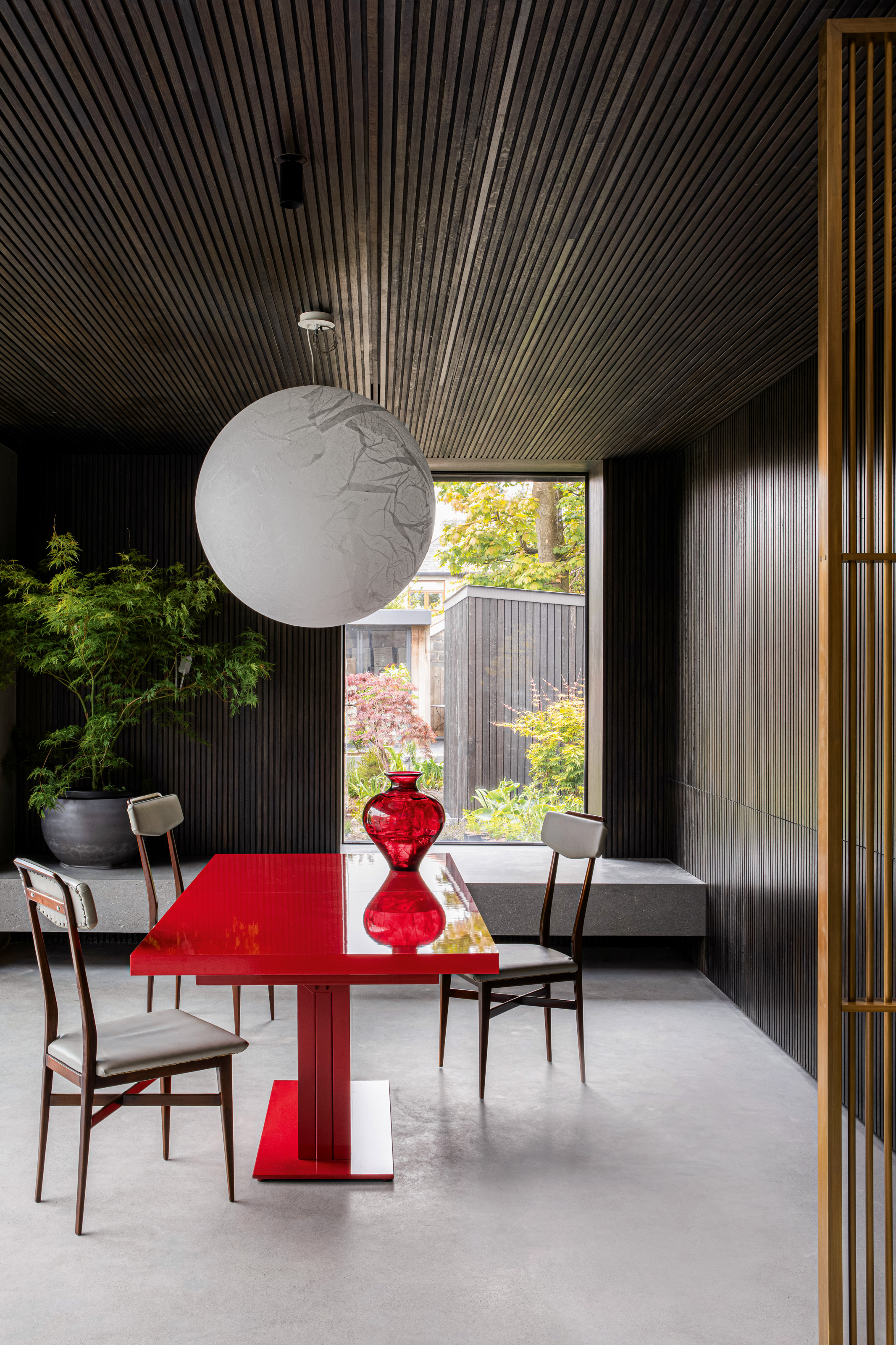 Wood-clad dining room with red lacquer dining table