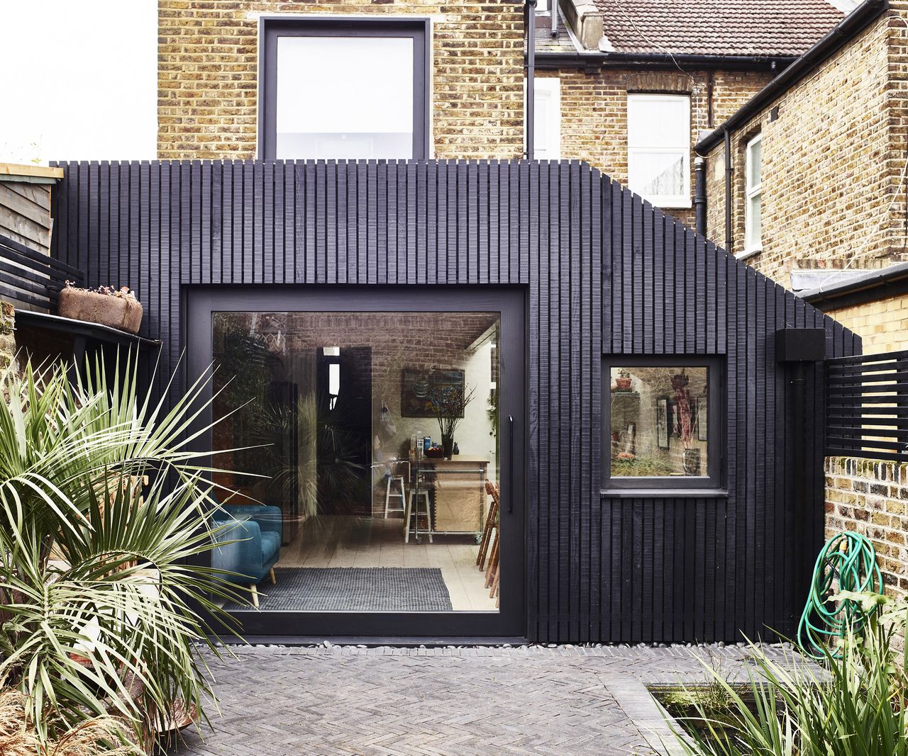 A dark timber clad kitchen extension on a semi detached house