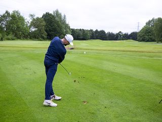 Barry Plummer hitting an iron shot from the fairway at Burhill Golf Club