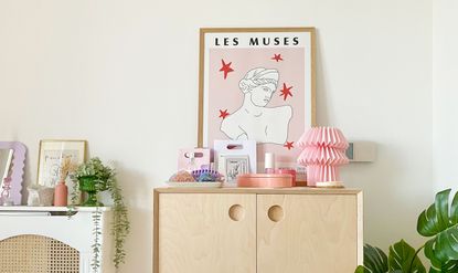 Wooden scandi console with pink lamp shade accent decor and leaning pink line drawing print