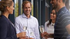 Colleagues socializing over wine in a modern office