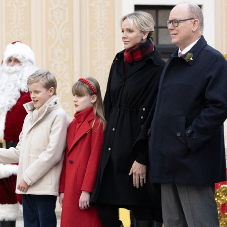 Princess Charlene, Prince Albert, Prince Jacques, Princess Gabriella bundled up in coats standing with Santa Claus 