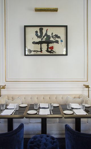 Palazzo Dama dining alcove with cream banquette and brass trimmed tables