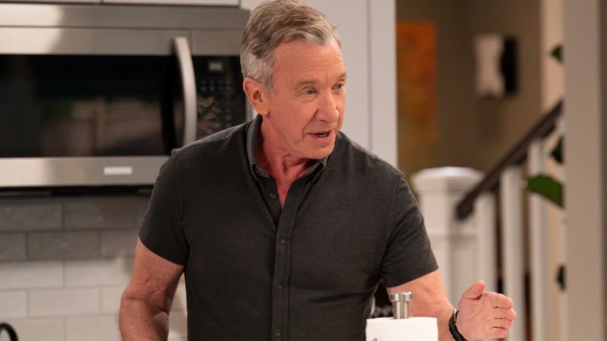 Tim Allen talking while standing in the kitchen. He&#039;s holding up his right hand while talking. 