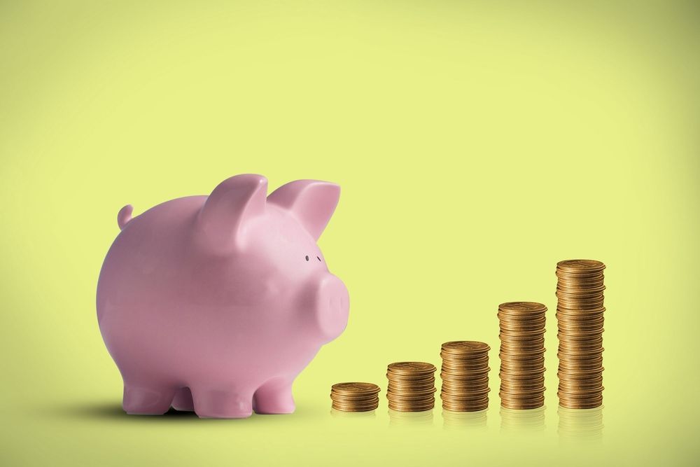 A piggy bank looking at stacks of pound coins 