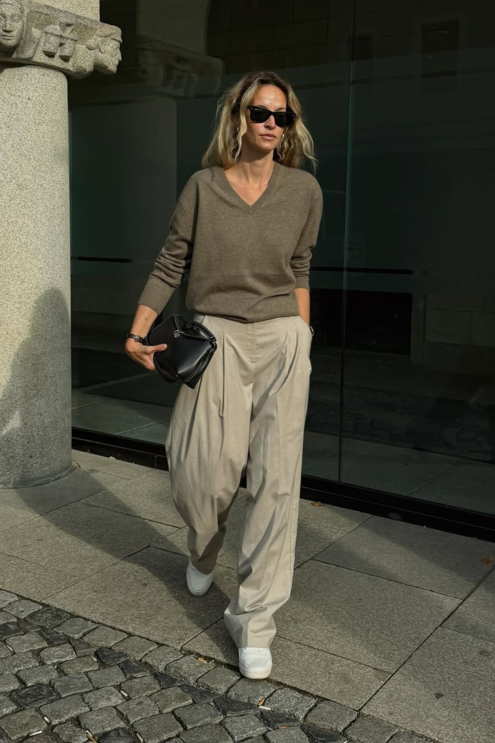 @anoukyve wears brown V-neck jumper, wide-leg trousers