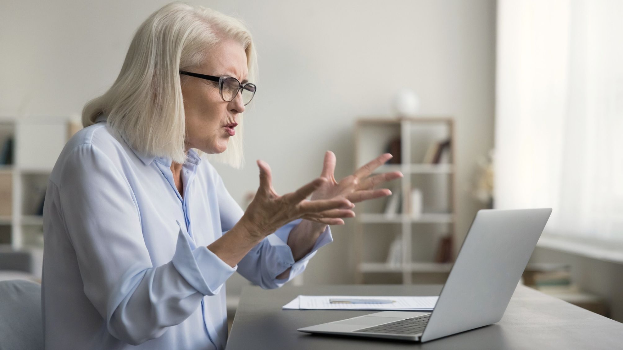 A woman frustrated with her laptop at home.