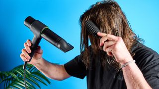 A man drying his hair with the Heist 3.0 Men's Hair Dryer