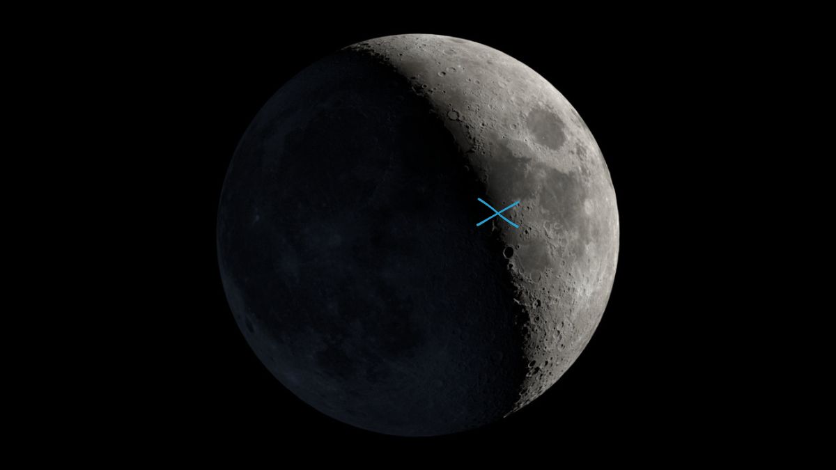 close up view of the moon with a blue cross to the right of the terminator