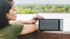 Victrola Music Edition 2 Portable Bluetooth Speaker review: woman using a speaker outside
