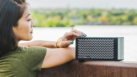 Victrola Music Edition 2 Portable Bluetooth Speaker review: woman using a speaker outside