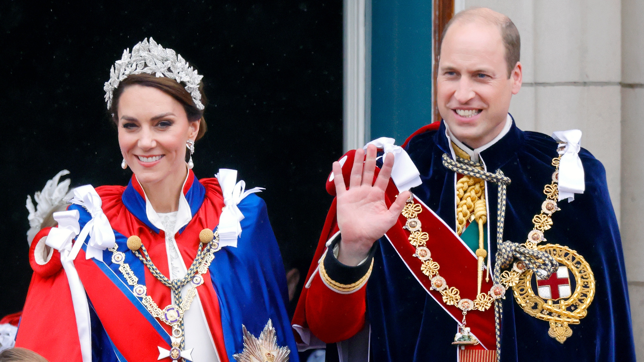 Catherine, Princess of Wales (wearing the Mantle of the Royal Victorian Order) and Prince William, Prince of Wales (wearing the Mantle of the Order of the Garter) watch an RAF flypast from the balcony of Buckingham Palace following the Coronation of King Charles