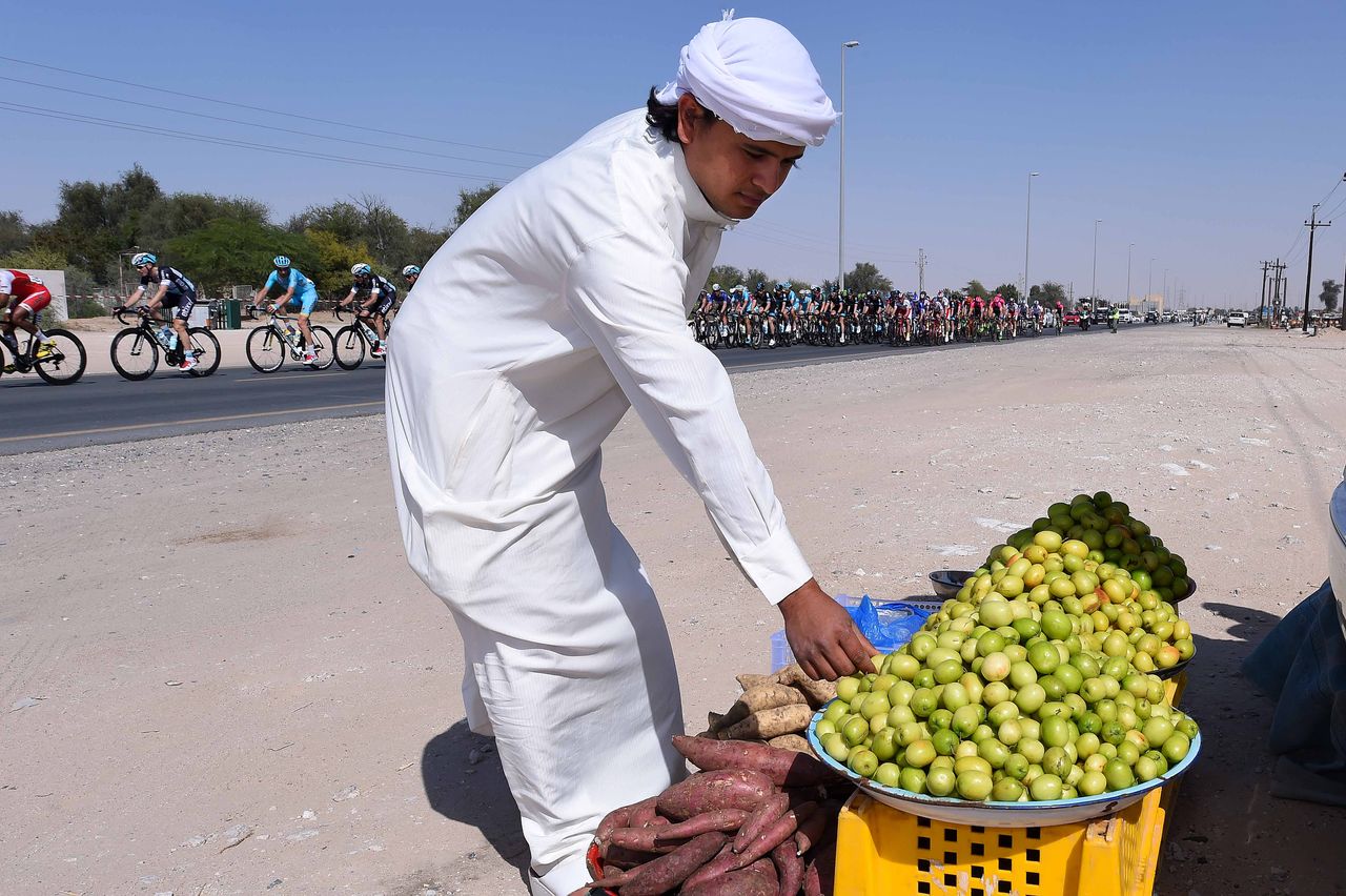 A local tradesman tends to his stock as the peloton wizz by
