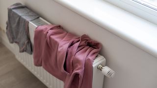 clothes drying on a radiator next to a window