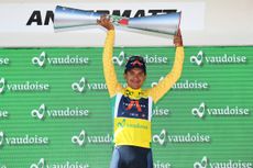 Richard Carapaz lifts the Tour de Suisse trophy aloft while wearing the leaders yellow jersey