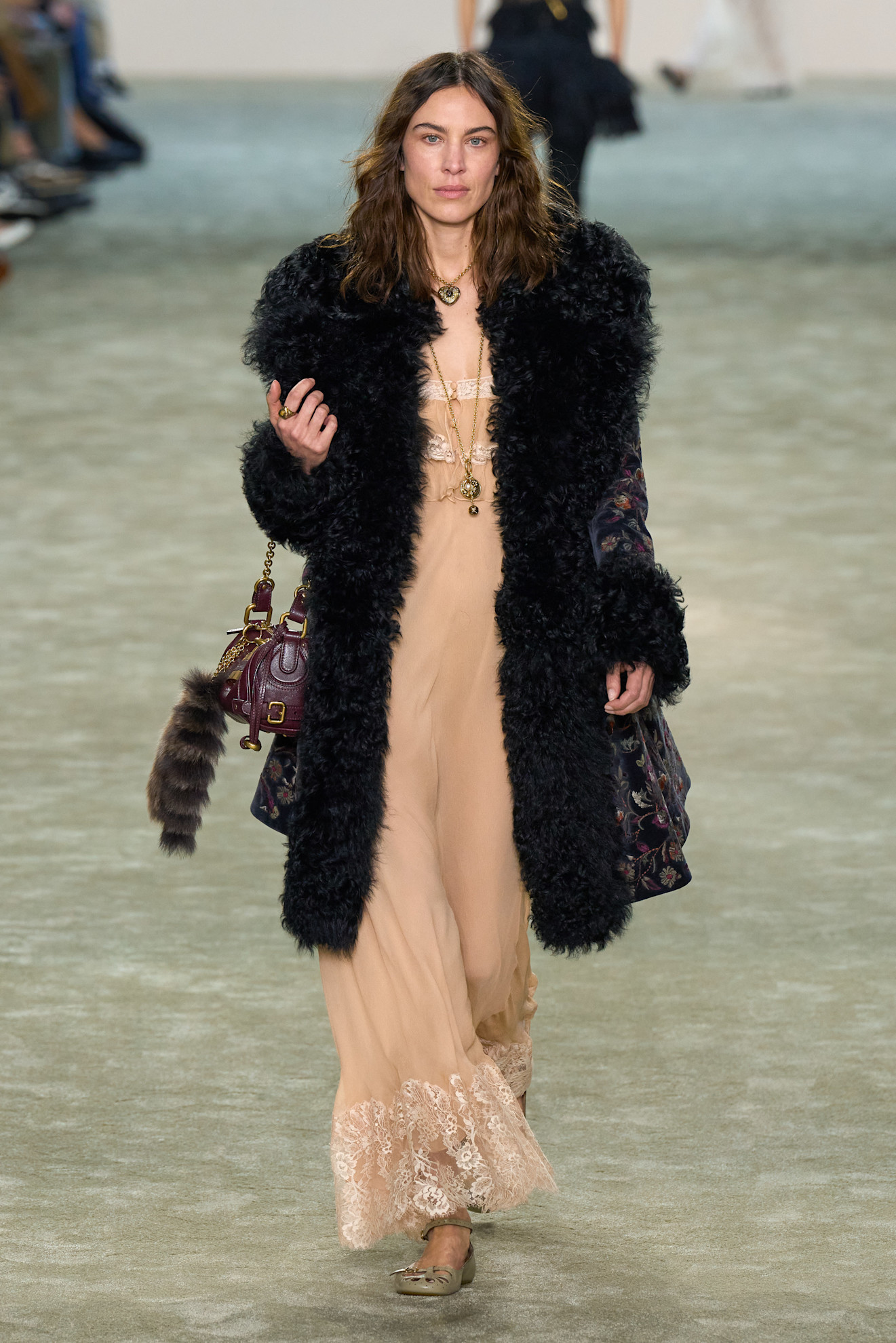 Alexa Chung wears brown leather jacket, blue and black striped sweater, and brown leather bag at the Chloe fashion show during the Womenswear Fall/Winter 2025/2026 as part of Paris Fashion Week on March 06, 2025 in Paris, France.
