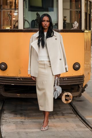 Celebrity Skirt Outfits: Jasmine Tookes wears a beige pencil skirt with a beige cropped trench