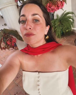 woman wearing a red neck scarf and gold earrings