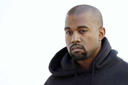 Kanye West poses before Christian Dior 2015-2016 fall/winter ready-to-wear collection fashion show on March 6, 2015 in Paris.