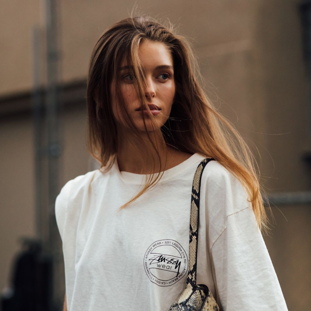 blonde fashion week attendee looking away from camera wearing white top