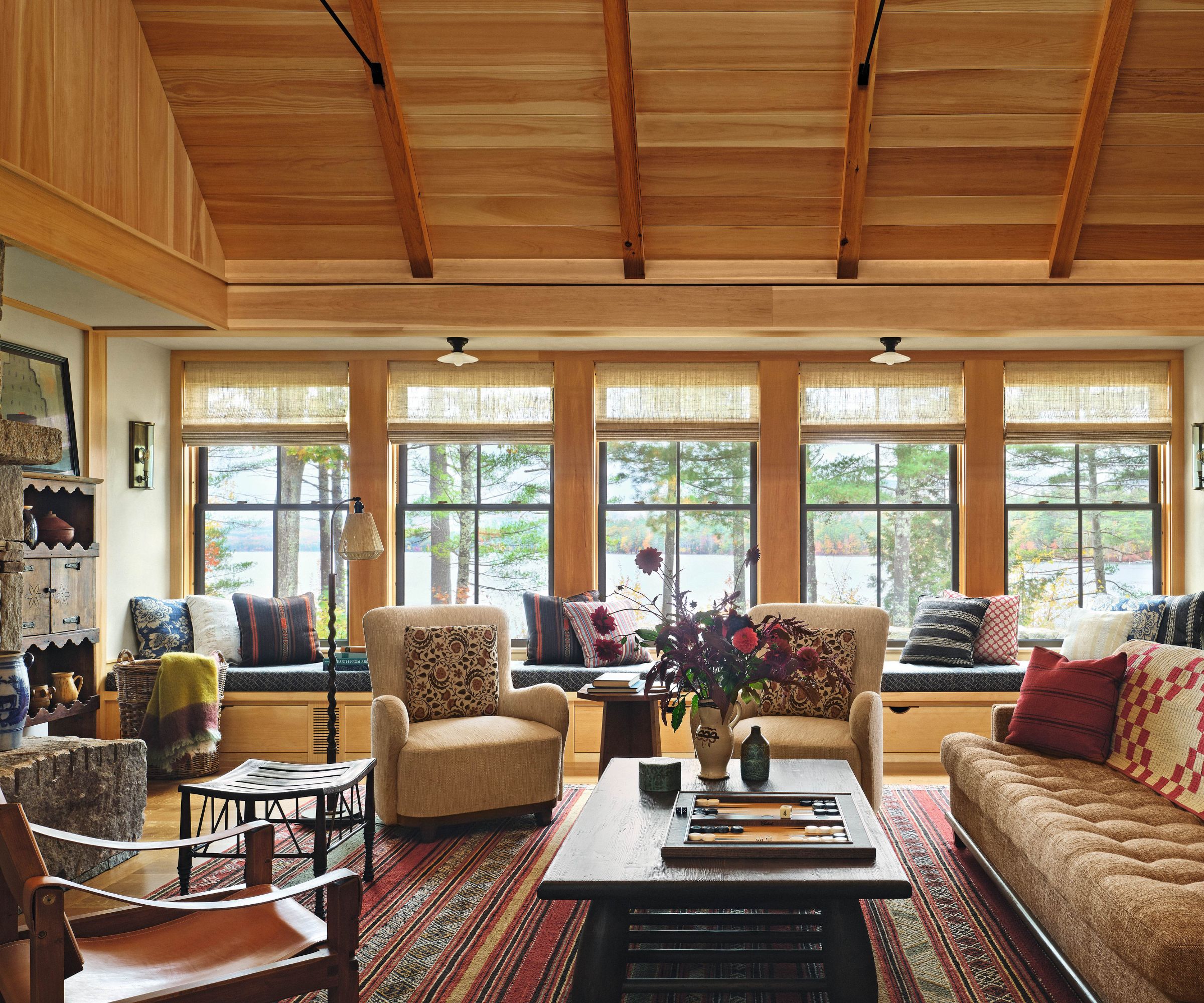 Wood panelled living room with large rug and central coffee table