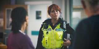 Police officer Ffion Morgan (Stirling Gallacher) waits outside while Tess and Charlie attempt to talk Laura down...