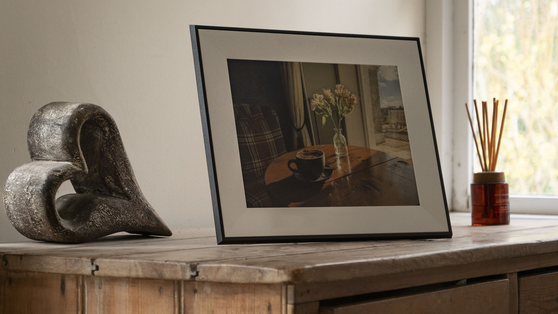 The Aura Ink 'E Ink' digital photo frame on a sideboard