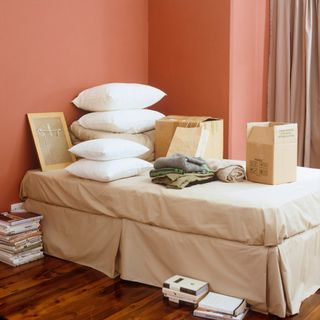 red wall with white cushions and cloths with boxes