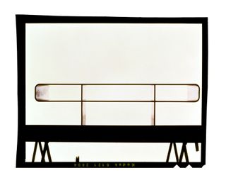 A 1990s polaroid of Barber Osgerby Loop table showing its simple silhouette against bright light