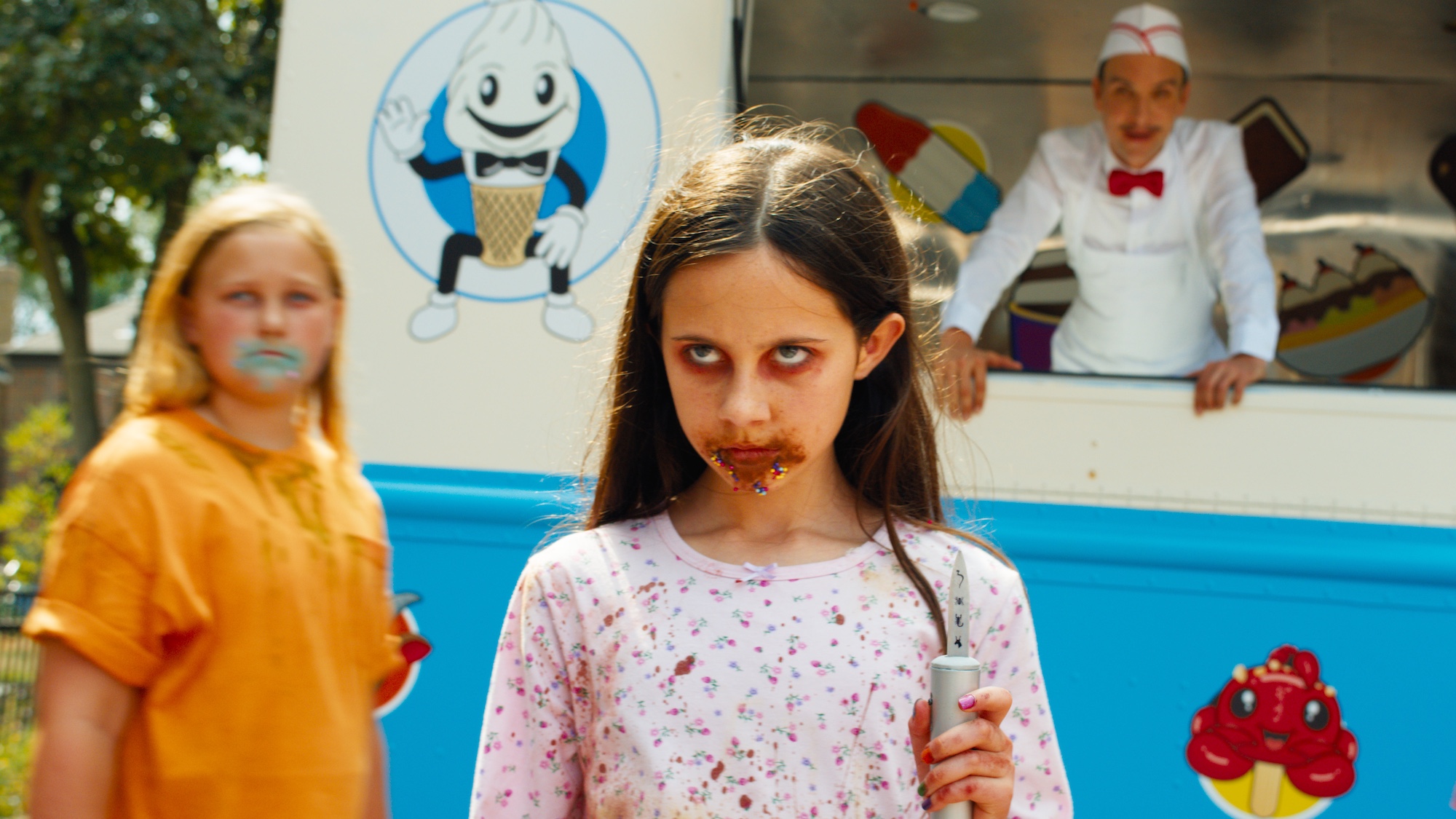 child with a bloody mouth and a knife in front of an ice cream truck in Ice Cream Man 