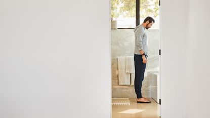 Fitbit Aria Air review: men looking at bathroom scale