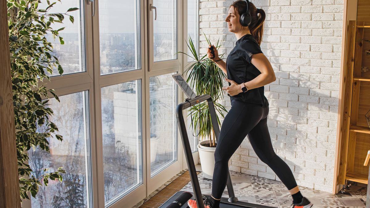 Should you buy a treadmill: Image shows woman using treadmill in apartment