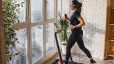 Should you buy a treadmill: Image shows woman using treadmill in apartment