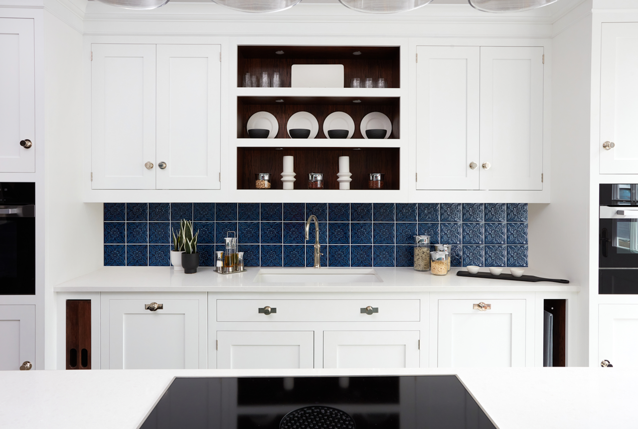 white kitchen with navy victorian style tile backsplash