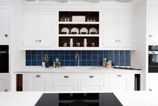 white kitchen with navy victorian style tile backsplash
