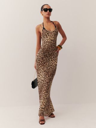 Reformation model wearing leopard maxi dress and black heels