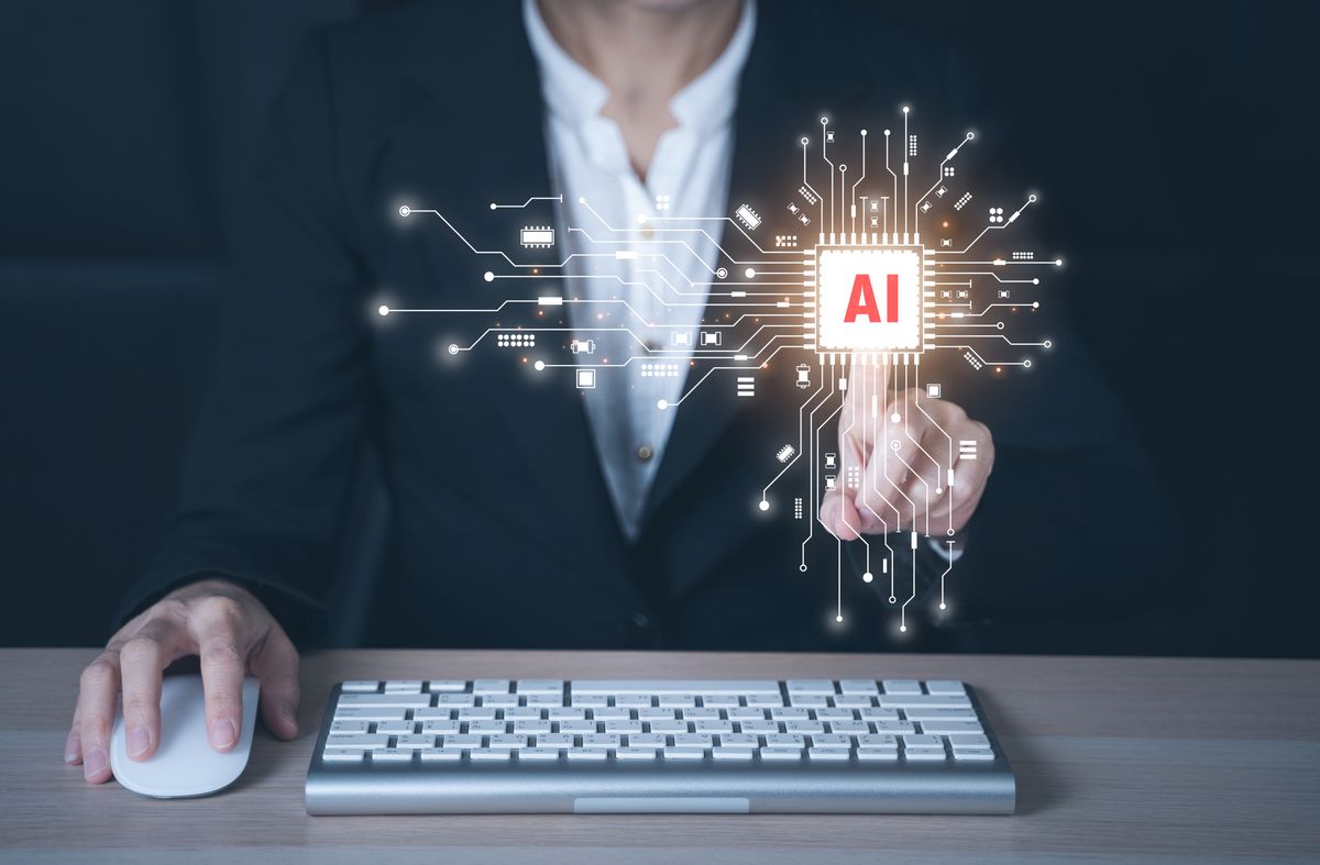 A man pressing an AI button over a keyboard.